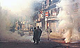Kashmiri Muslim protesters run from tear-gas during a protest in Srinagar.