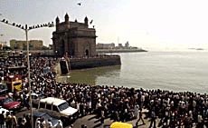 People of the port city of Bombay crowd the Gateway of India waterfront on Friday to watch the International Fleet Review.