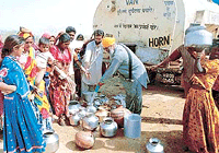 Water is supplied through a tanker to the quake hit in Trambo village of Gujarat on Saturday. 