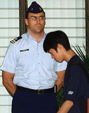 An unidentified Japanese family member of a victim of the sunken Ehime Maru walks into the US Coast Guard Station in Honolulu to view a tape of the fishing trawler shot by US Navy submergibles 2,000 feet underwater. 