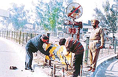 Policemen clean a signboard along a road in Ludhiana.