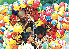 Gujarati children sell balloons at Rose Festival in Chandigarh on Friday.