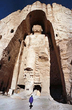 A visitor walks past the 55-metre-high Buddha statue at Bamiyan, central Afghanistan, in this December 18, 1997 file photo.