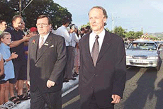 John Bradman (R), son of Sir Donald Bradman and funeral director David Llloyd (L) on Thursday escort a hearse carrying the body of Sir donald Bradman past mourners on the way to a private family funeral service in Adelaide. 
