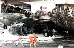 Workers spray foam chemicals on the burnt remains of a Thai Airways Boeing 737 on the tarmac at Bangkok airport on Saturday. 