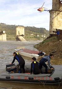 Divers prepare to start their rescue work in front of the collapsed bridge at Castelo de Paiva over the Douro river in Portugal on Monday.  