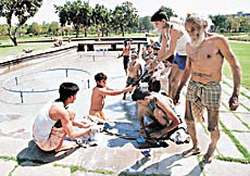 A group of farmers who have come to Chandigarh to take part in protest rallies, wash their clothes at the Rose Garden fountain in Sector 16, Chandigarh, on Saturday.