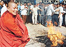 A Buddhist monk beats an effigy of Taliban leader Mullah Mohammed Omar with a stick in Mumbai