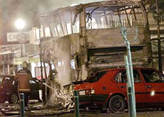 A fireman extinguishes a smouldering bus early on Sunday after a car bomb exploded in the north-eastern Spanish town of Rosas. A police officer was killed and another injured when the bomb exploded late on Saturday in the latest attack blamed on the Basque separatist group, ETA. 