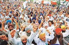 Farmers raise their arms in support of their demands at the Matka chowk in Chandigarh on Monday.