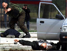 A Macedonian policemen gestures over the bodies of two ethnic Albanains shot dead in the town of Tetovo, some 50 km northwest of the capital on Thursday. 