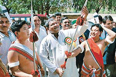 Mr Jual Oram, Union Cabinet Minister for Tribal Affairs, examines a tribal weapon at the Millennium Tribal Cultural Programme-2001 on Saturday in Panjab University