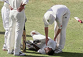 Brain Lara of West Indies lies on the ground in pain while Shaun Pollock of South Africa helps him, during the third day of the third Test at Kensington Oval in Bridgetown, Barbados, on Saturday.