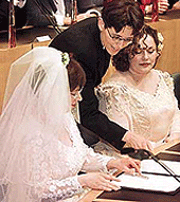 Helene Faasen (left) and Anne-Marie Thus are instructed how to sign their wedding certificate during the world�s first gay marriage in the Amsterdam town on Sunday.