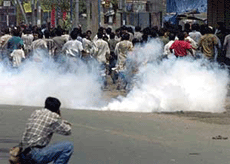 Bangladeshi Opposition activists run for cover as police fire tear gas shells in Dhaka on the second day of the three-day strike on Monday.