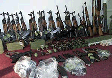 Weapons captured from the residence of former President Slobodan Milosevic in Belgrade are stacked up against a wall during a press conference by the Serbian Interior Ministry on Monday.