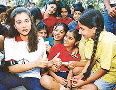 Indian model Lisa Ray chats with school children in Chandigarh, on Thursday.