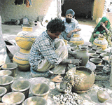 A potter makes pots in preparation for summer sale. 
