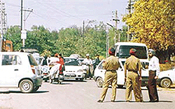 Three policemen (one in mufti) stand guard and divert traffic in Model Town area where Mr Sukhbir Badal was to inaugurate a diagnostic centre on Friday.