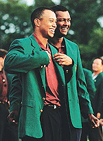 Tiger Woods of the USA (L) smiles as he receives the traditional green jacket from former winner Vijay Singh (R) of Fiji to signify his win of the Masters at Augusta National Golf Club.