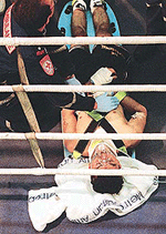 Boxer Ahmed Popal is attended to by an ambulance officer after he fell heavily, hitting his head during a bout in Melbourne on Friday. 