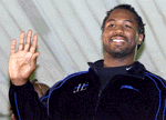 World heavyweight boxing champiom Lennox Lewis waves upon his arrival in South Africa to defend his title against Hasim Rahman.