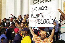 NAACP president Kweisi Mfume ( top left with raised arm) speaks to a large crowd at the New Friendship Baptist Church in Cincinnati on Thursday.