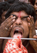A Hindu devotee has is tongue pierced with an iron rod during a religious festival in the eastern Indian village of Bainan in West Bengal state on April 13, 2001.