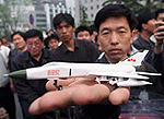 Chinese Liang Jianping displays a model of the Chinese F-8 fighter jet which crashed after colliding with a U.S. EP-3 spy plane, during a protest outside the Foreign Ministry in Beijing on Wednesday.