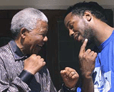 British heavyweight boxer Lennox Lewis (R) shows former President Nelson Mandela on Monday his jaw where he took a knockout punch from challenger American Hasim Rahman in the fifth round of Sunday's heavyweight championship fight at Carnival City in Brakpan.