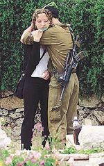 An Israeli soldier comforts his friend as they visit the graves of fallen colleagues on Memorial Day in Jerusalem's Herzel Military Cemetery April 25, 2001. Israelis honuored their soldiers who have been killed since Israel's Independence in May 1948. Tens of thousands of people visited Israel's 42 military cemeteries to visit the graves of loved-ones and to attend official ceremonies.