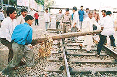 Activists from the militant right-wing Shiv Sena place wooden beams across railway tracks to enforce a strike in Bombay on Wednesday.