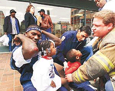 World heavyweight champion Hasim Rahman holds up his bloodied elbows for paramedics as his daughter Amirah and son Shariff sit on his lap on Wednesday. 