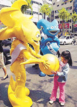 The mascots of the 2002 World Cup Korea-Japan Ato (left) and Nik play with a child on the street in Seoul.