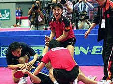 China's Liu Guozheng, lying on the floor, is congratulated by Ma Lin (standing) and other team-mates after beating South Korean Kim Taek-Soo in the final match of their semifinal clash in the men's team competition at the 46th World Table Tennis Championships at Osaka, western Japan, on Saturday. 