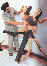 Sculptor Piara Singh explains the concept behind one of his wood creations on display at Indus Ind Bank Art Gallery, Sector 8, on Tuesday. 