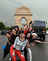 New Delhi: A group of foreigners enjoying in front of India gate on Tuesday after mercury dips in the capital due to a brisk dust storm followed by rain.