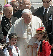 Pope John Paul II is welcomed by Greek children Christos Harikopoulos (7)and Louisa Kornaros (8), both dressed in the national costume, on arrival at Athens airport on Friday. 