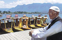 Mohammed Sultan, a Kashmiri shikara owner, sits on the banks of the Dal Lake in Srinagar on Sunday. 