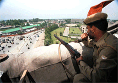 A policeman positioned atop a building keeping vigil on the main road leading to the civil Secretariat, seat of J&k Government, ahead of the reopening of darbar move in the summer capital Srinagar on Tuesday. 
