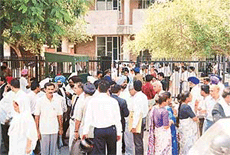 Lawyers, litigants and employees of the District Courts stand outside the gate of the court after a bomb hoax on the District Courts premises, Sector 17, Chandigarh, on Friday.