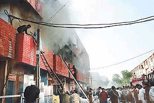 Firemen fighting the flames amidst dense smoke after a major fire broke out in a Sector 22-D showroom in Chandigarh on Saturday.