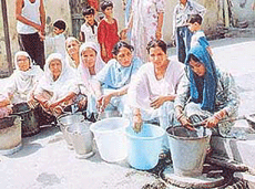 Women of Bharagava Camp in Jalandhar wait for their turn at a public water post on Saturday.