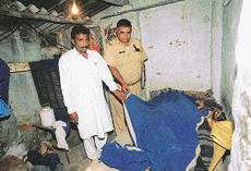 A police official inspects the body of a woman who was allegedly beaten up and strangulated by her husband in Rajiv Colony, Sector 17, Panchkula, on Sunday.
