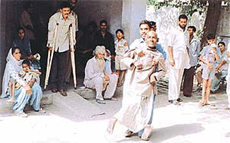 Physically and mentally challenged persons wait outside the office in the heat to obtain certificates of disability.