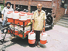 Water being carried in containers to shops in a Ludhiana market.