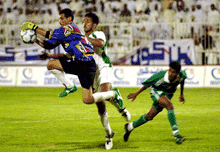 Yemen goalkeeper, Muod Abdulkhalek catches the ball as UAE's Yaser Salem Saleh, closes in on during the World Cup qualifying group 8, preliminary competition in Al Ain, the UAE, on Friday. Player at right is unidentified. 