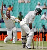 Australian bowler Shane Warne (left) celebrates after clean bowling 