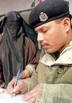 A veiled Kashmiri Muslim woman registers her name with a BSF man for free medical assistance