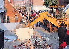 The front boundary wall of a housing board flat being demolished by a squad of PUDA in Phase-I of SAS Nagar on Tuesday.